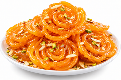 A plate of golden-brown Indian jalebi syrup sweets, stacked in a spiral pattern and garnished with sliced almonds and chopped pistachios on a white plate against a white background.